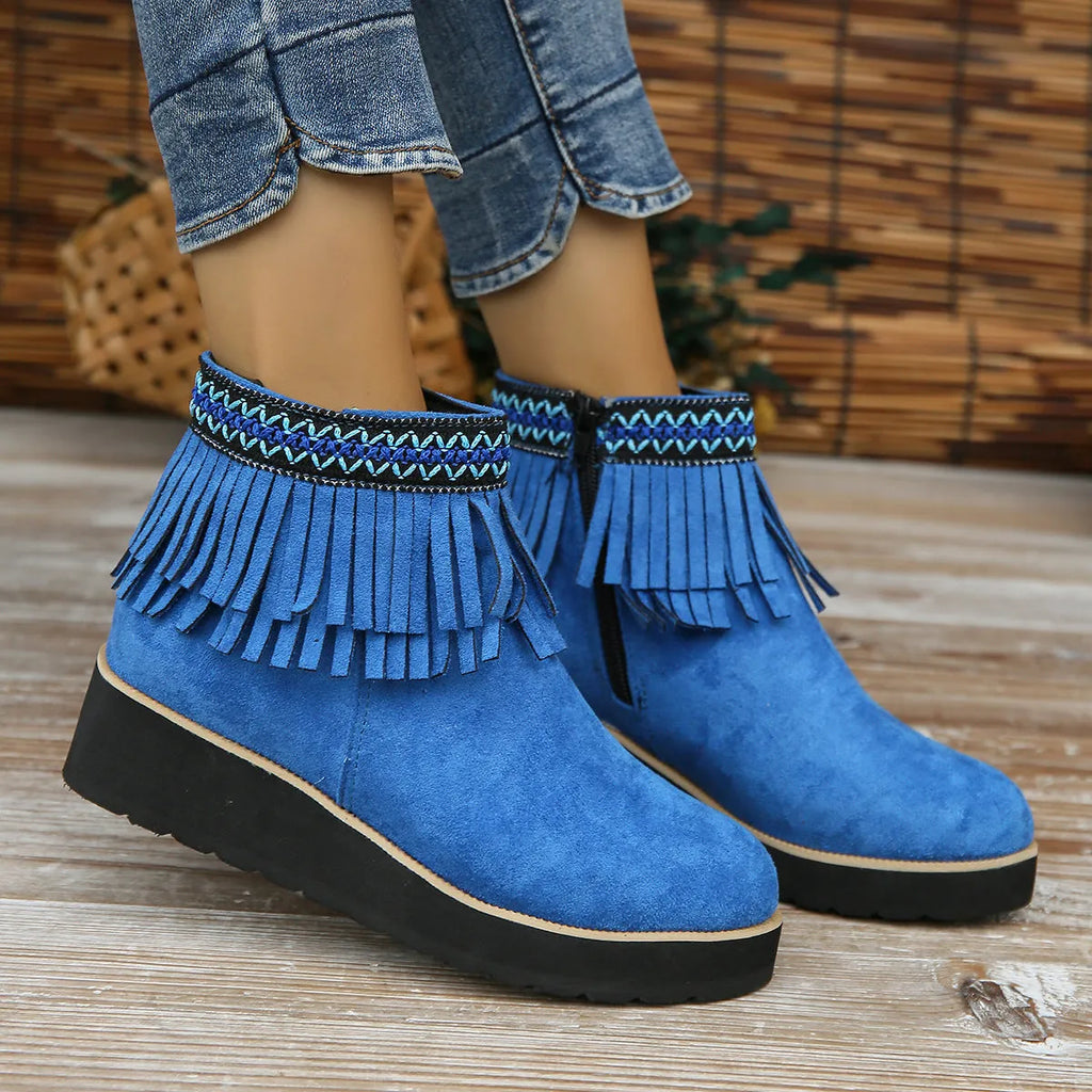 Women's black suede wedge ankle boot with side zip and tassel detail on a thick rubber platform sole.