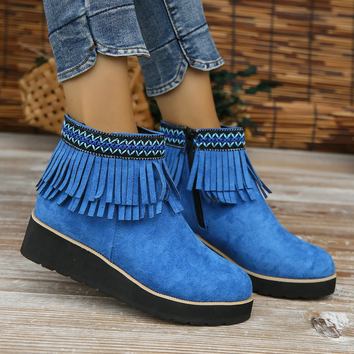 Women's black suede wedge ankle boot with side zip and tassel detail on a thick rubber platform sole.