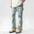 Yellow and blue retro patchwork jeans with splash-ink distressed detailing, showing mid waist and zip fly.