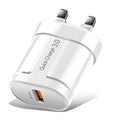 White and black mobile phone travel chargers with UK, US, and EU plug attachments on a table