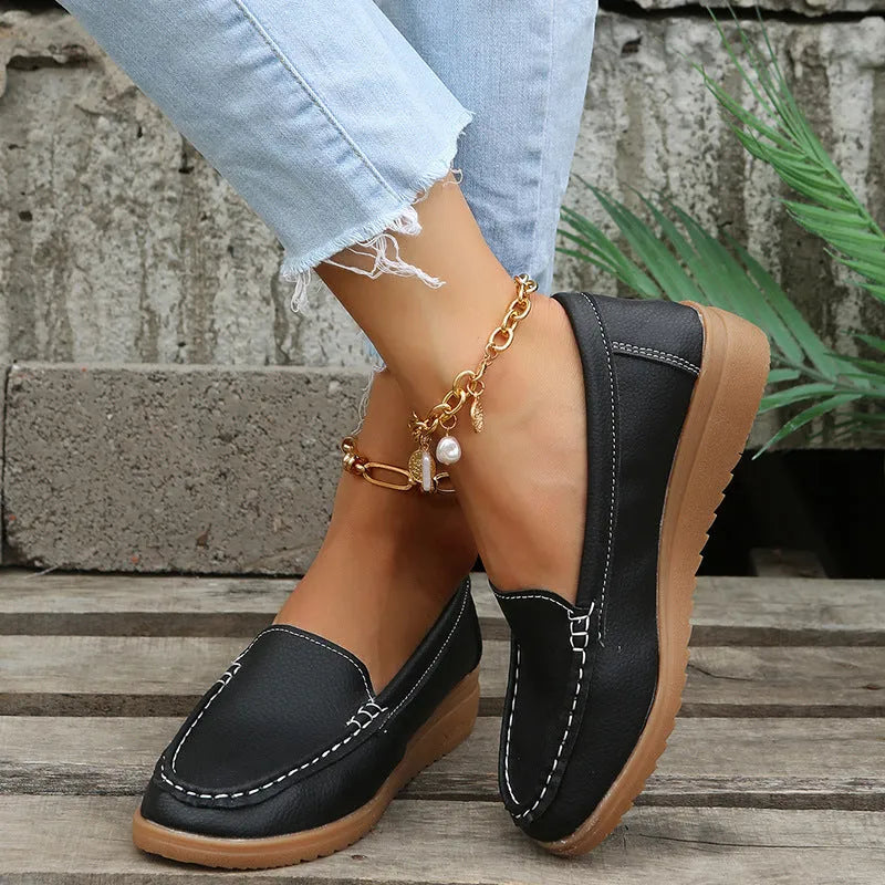 Women's black PU leather flat shoes with round toe and visible car suture stitching detail.