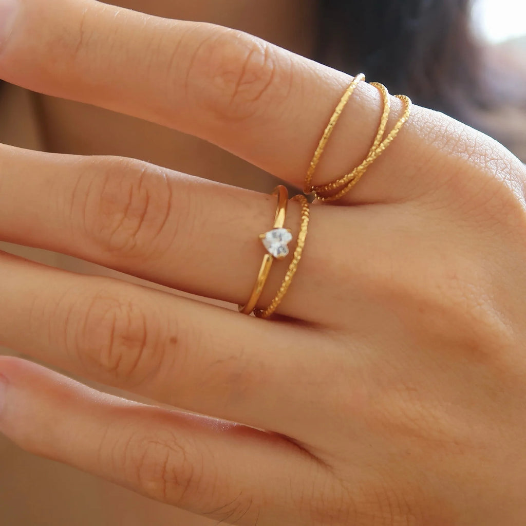 Golden stainless steel ring showing love heart and oval design options on a white background.