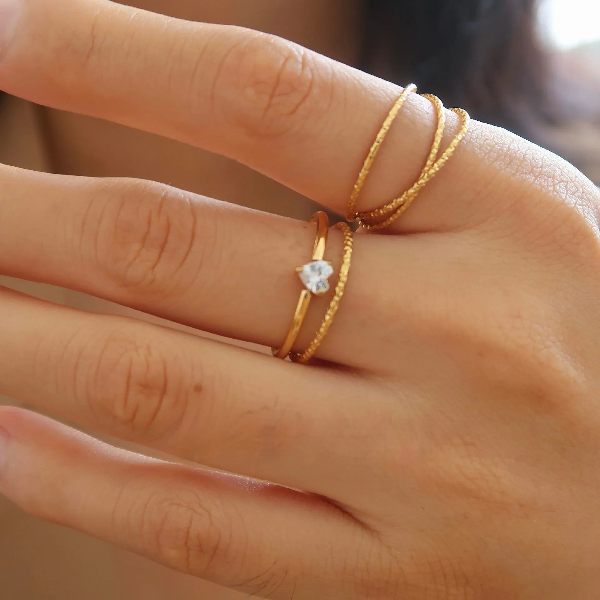 Golden stainless steel ring showing love heart and oval design options on a white background.