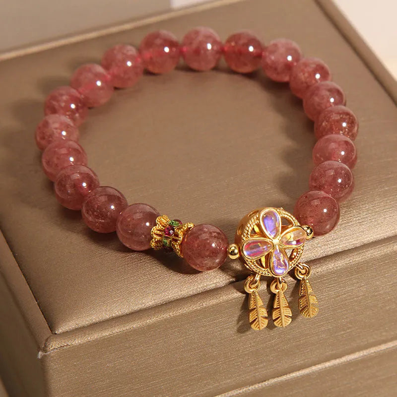 Women's strawberry quartz crystal bracelet with a four-leaf clover dream catcher ball pendant.