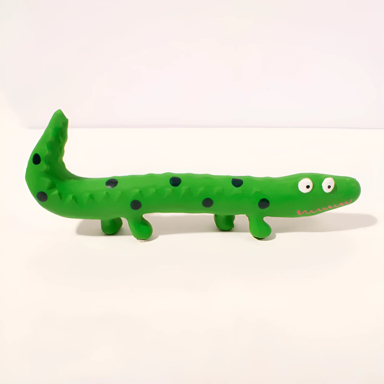 Green cartoon lizard shaped latex dog chew toy with squeaker on a white background