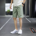 Men's loose-fit straight-leg casual beach shorts in polyester, shown in green.