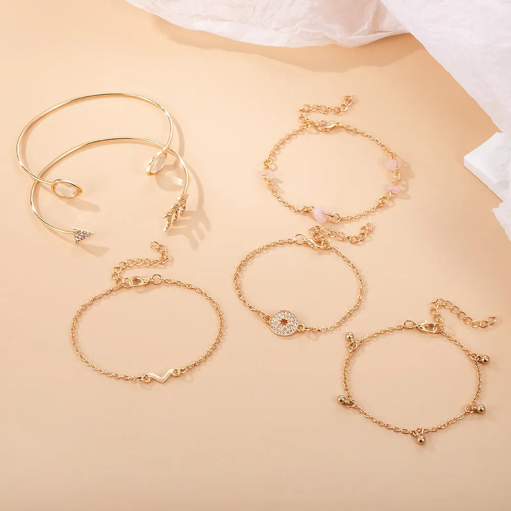 Gold-coloured women's bracelet set with six pieces showing spot drill arrow and water drop V-shaped charms