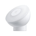 White modern bedside table lamp with human body induction and Bluetooth on a nightstand.