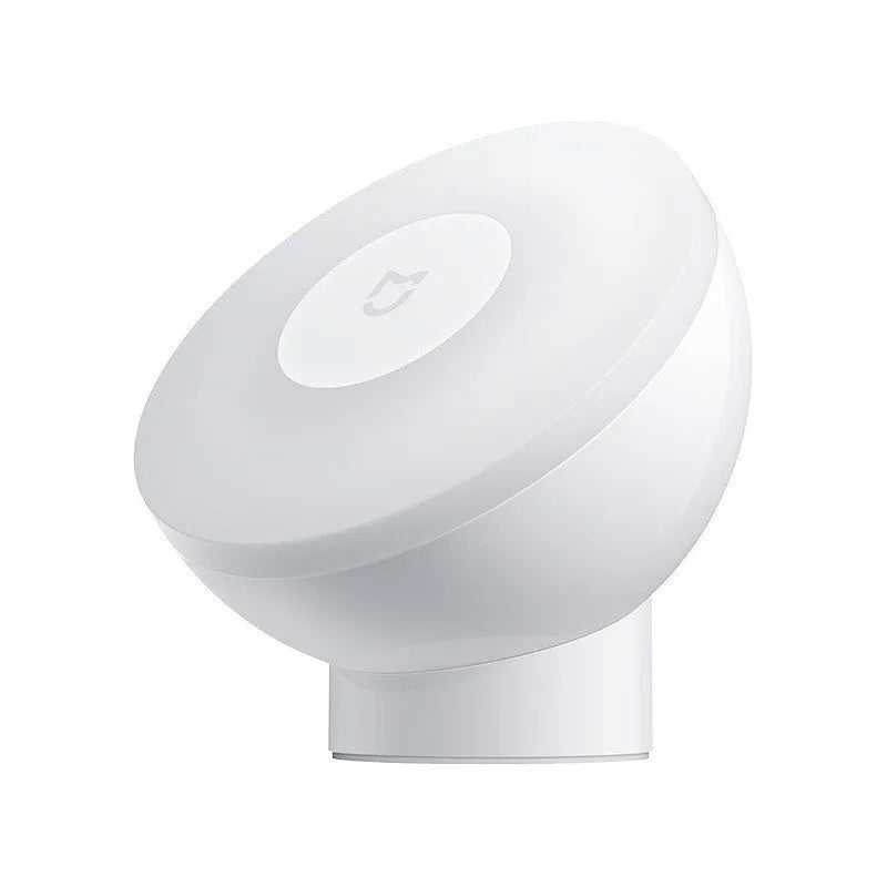 White modern bedside table lamp with human body induction and Bluetooth on a nightstand.