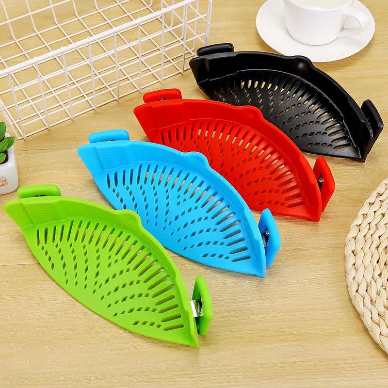 Silicone clip-on funnel strainer attached to a pot rim, showing hollow design and stainless steel buckle.