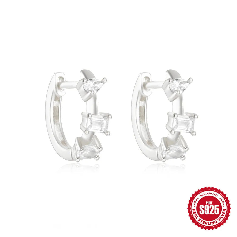 A pair of small, round, geometric stud earrings made of sterling silver with an electroplated finish.