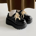 Black women's lace-up platform shoes with a chunky rubber sole and English muffin heel.