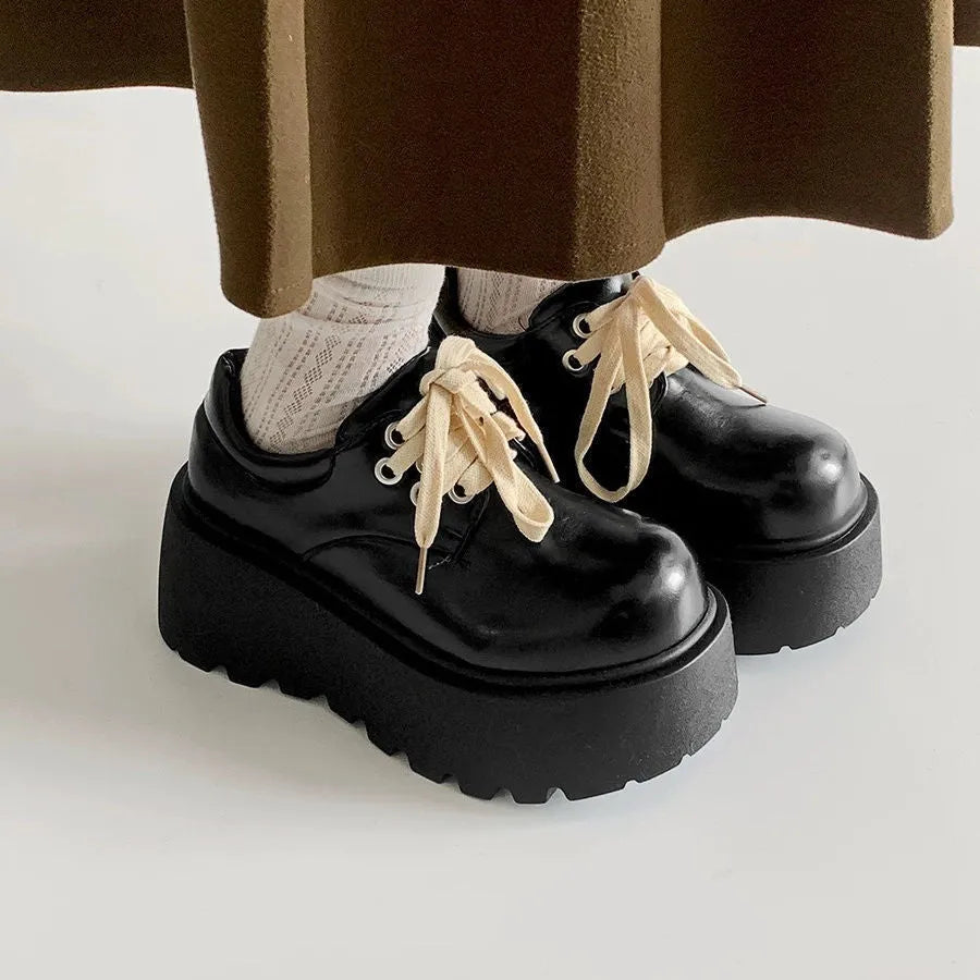 Black women's lace-up platform shoes with a chunky rubber sole and English muffin heel.
