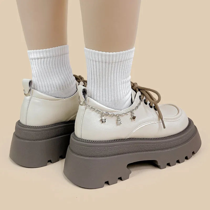 White platform Mary Jane shoes with chunky heel and front lace-up detail on a round toe.