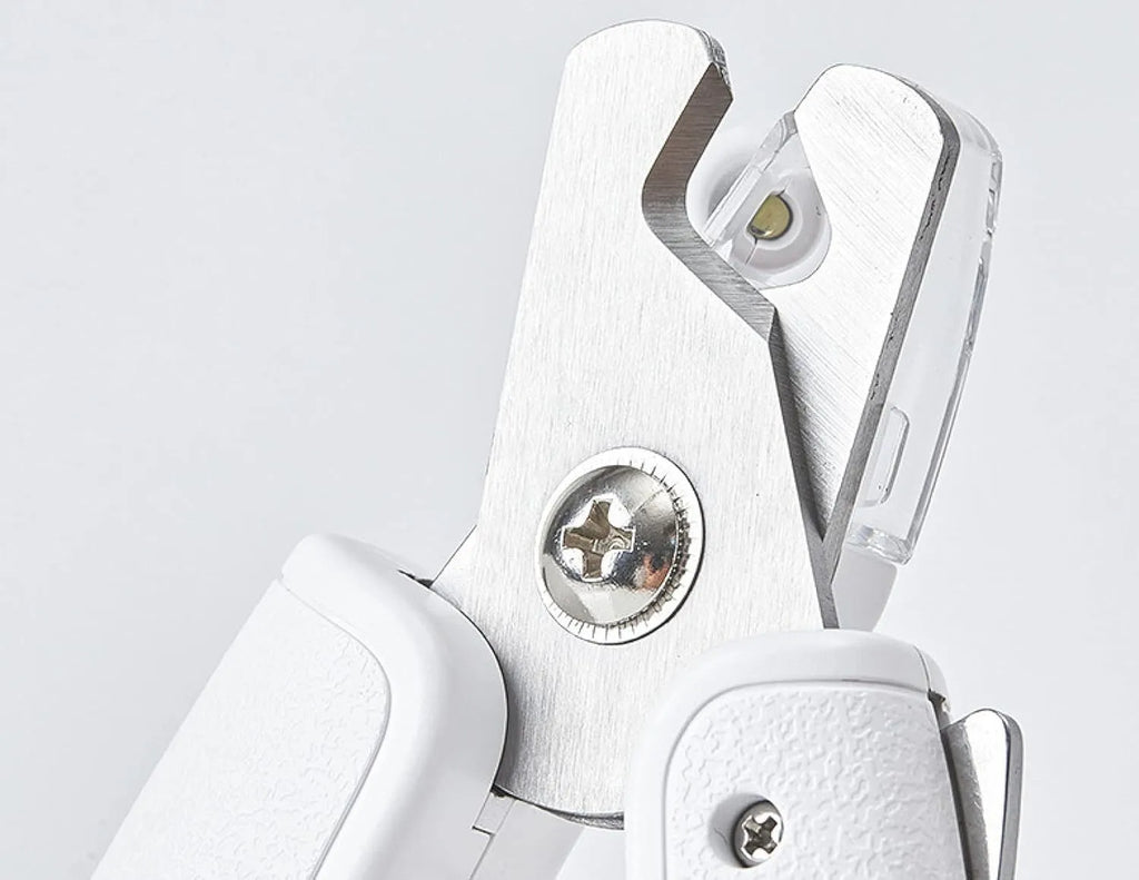 White pet nail clippers with LED light, transparent guard, and nail file for cats and dogs