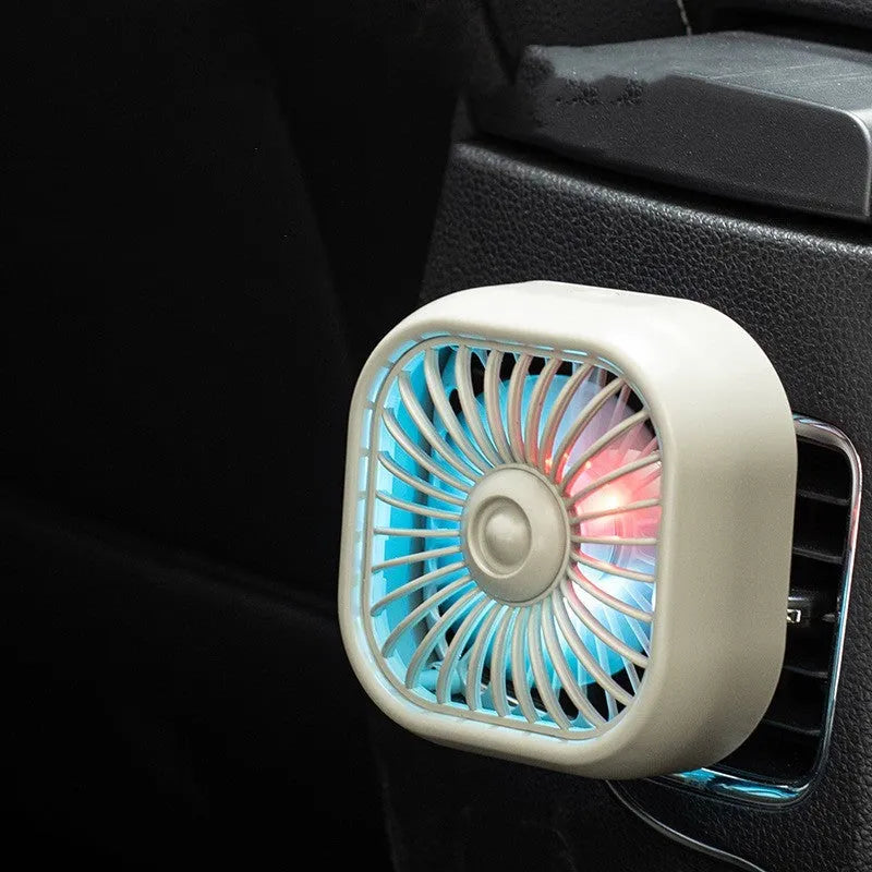 Small black USB fan with keyboard controls for three speed settings on car dashboard