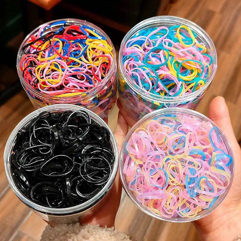 Multi-colour TPU baby hair ties for toddlers stored in a reusable clear container.