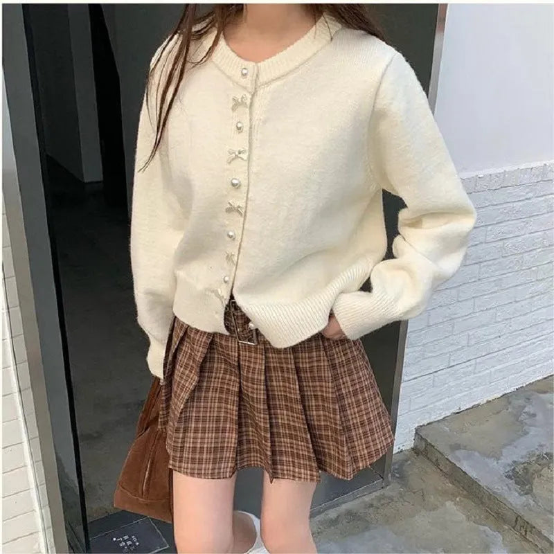 Women's solid colour cardigan sweater with bow and pearl button design in medium thickness fabric
