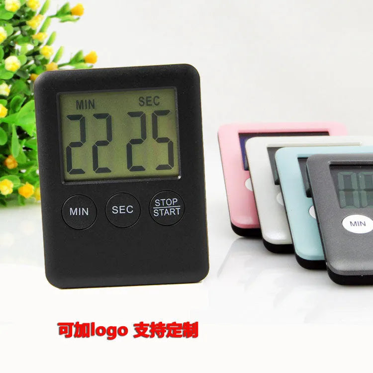 Black and white digital kitchen timer with magnetic back showing count up, countdown and alarm functions.