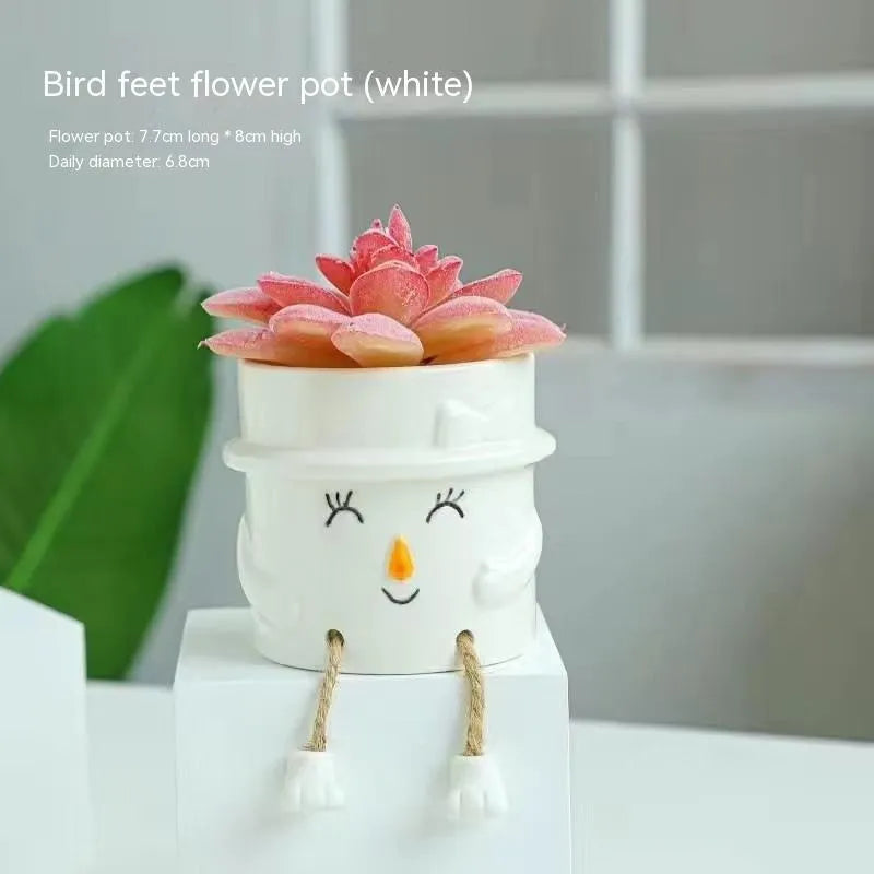 Cartoon style ceramic hanging foot flowerpot for succulent plants on a desktop.