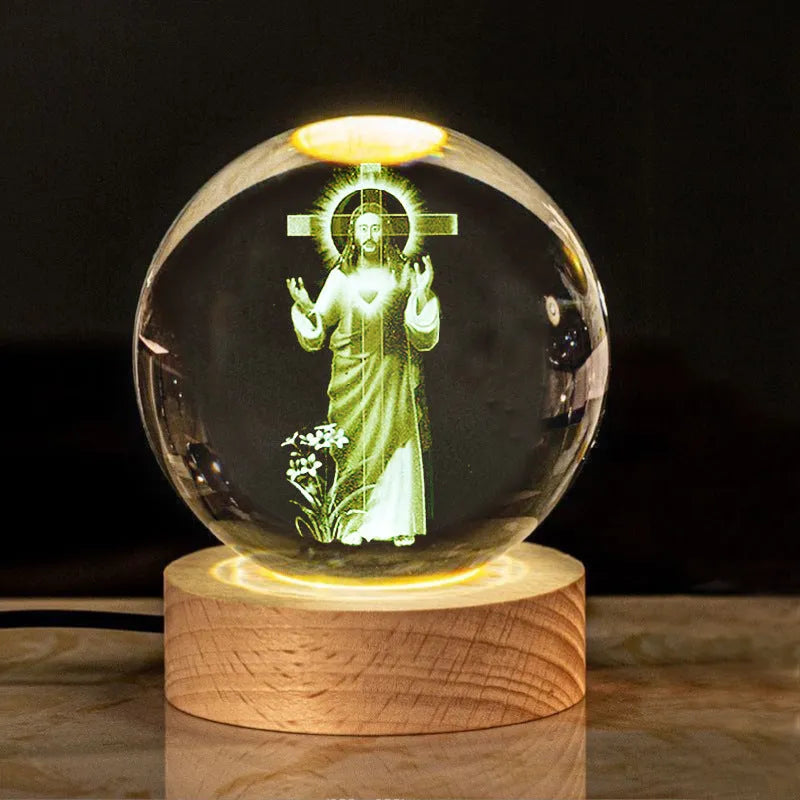 White crystal ball ornament on wood base with warm light and religious symbols