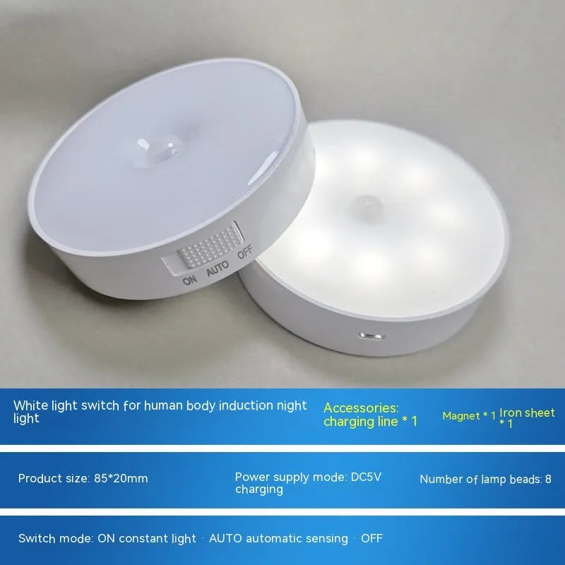Small white circular motion sensing LED night light with adhesive backing next to a USB charging cable.