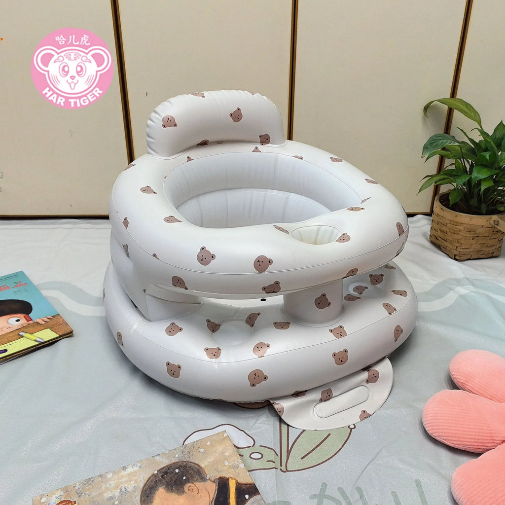 Inflatable infant dining chair in PVC with bear design, deflated beside a baby for scale