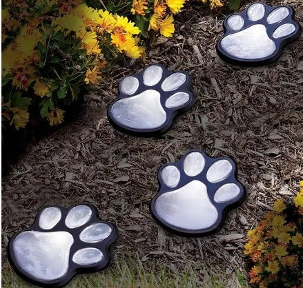 Black solar powered animal paw print LED garden lights set with four paw shapes and solar panel