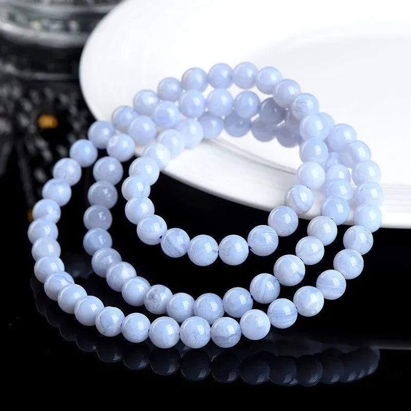 Blue agate bracelet with natural striped patterns, Ruyi design elements, and scattered bead arrangement
