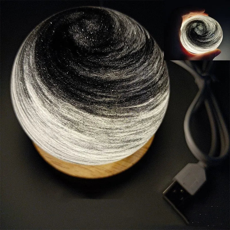 Planet night light with spherical design on base, USB cable connected, showing adjustable three-colour lighting