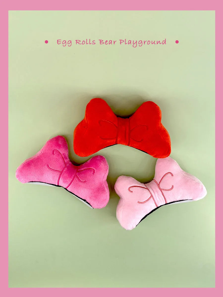 Plush bow tie helmet decoration in bright red, peach pink, and rose pink colours