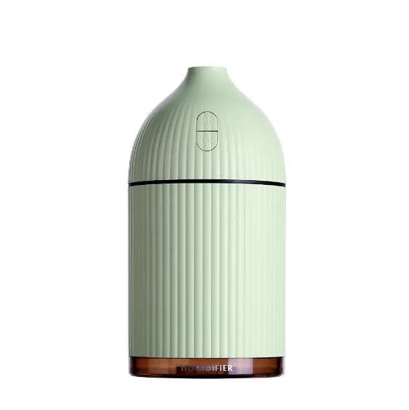 White ultrasonic aromatherapy diffuser with LED light and USB cable on a wooden table