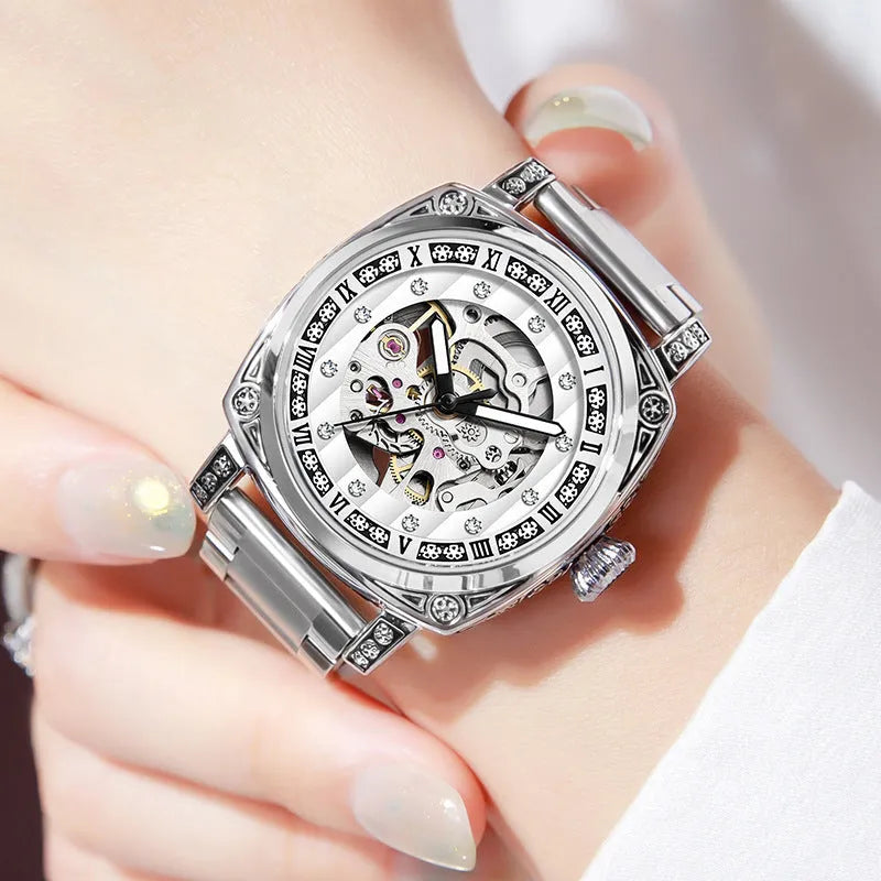 Mechanical watch with luminous hands on a leather strap, showing colour options of black, red, steel, and white dials.