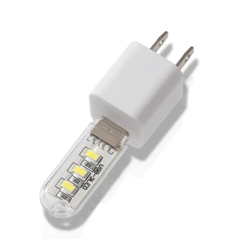 Small white USB-powered baby night light showing warm and white light options on a table