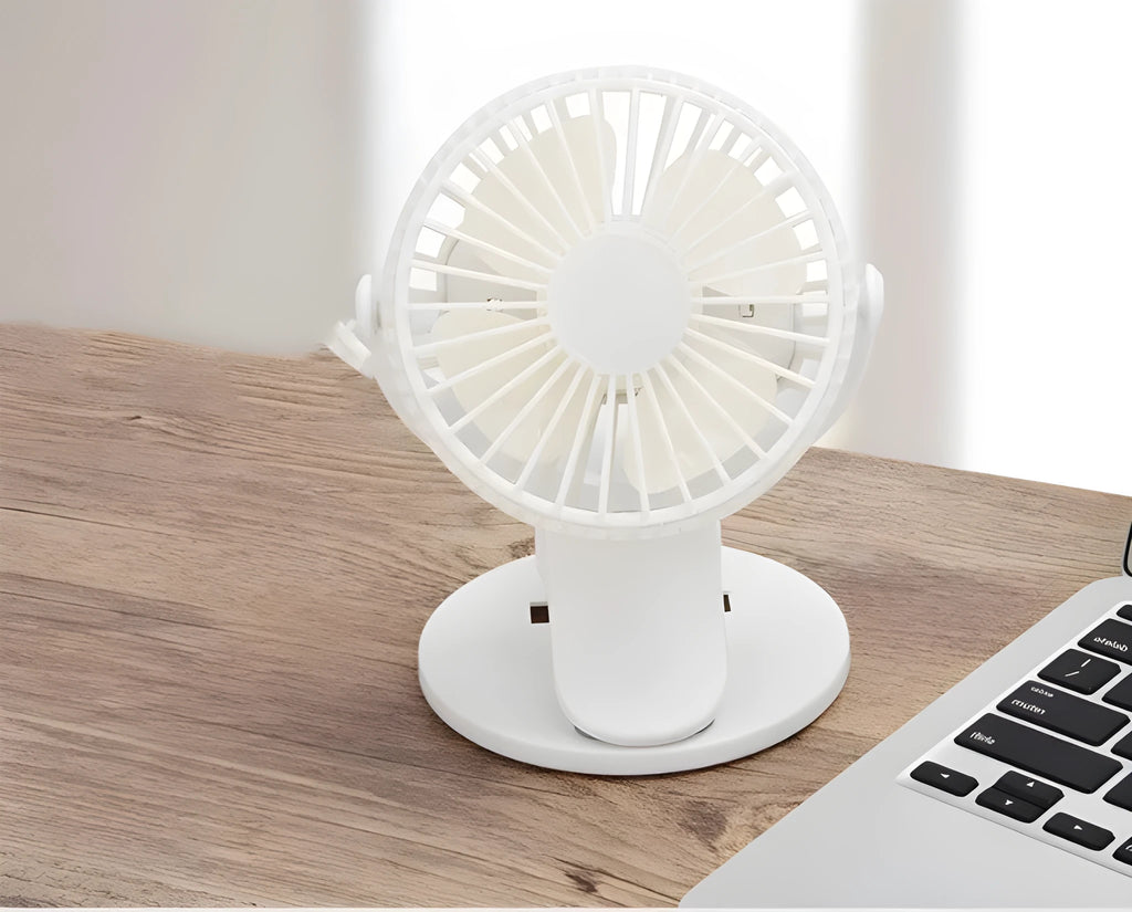 Small white clip fan with plastic blades attached to a surface, showing USB cable and piano button switch.