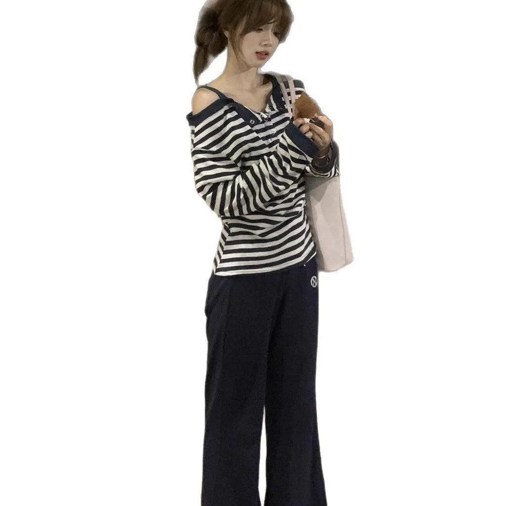 Dark blue oversized women's long-sleeve t-shirt with stripes, button detail, and embroidery on the front.