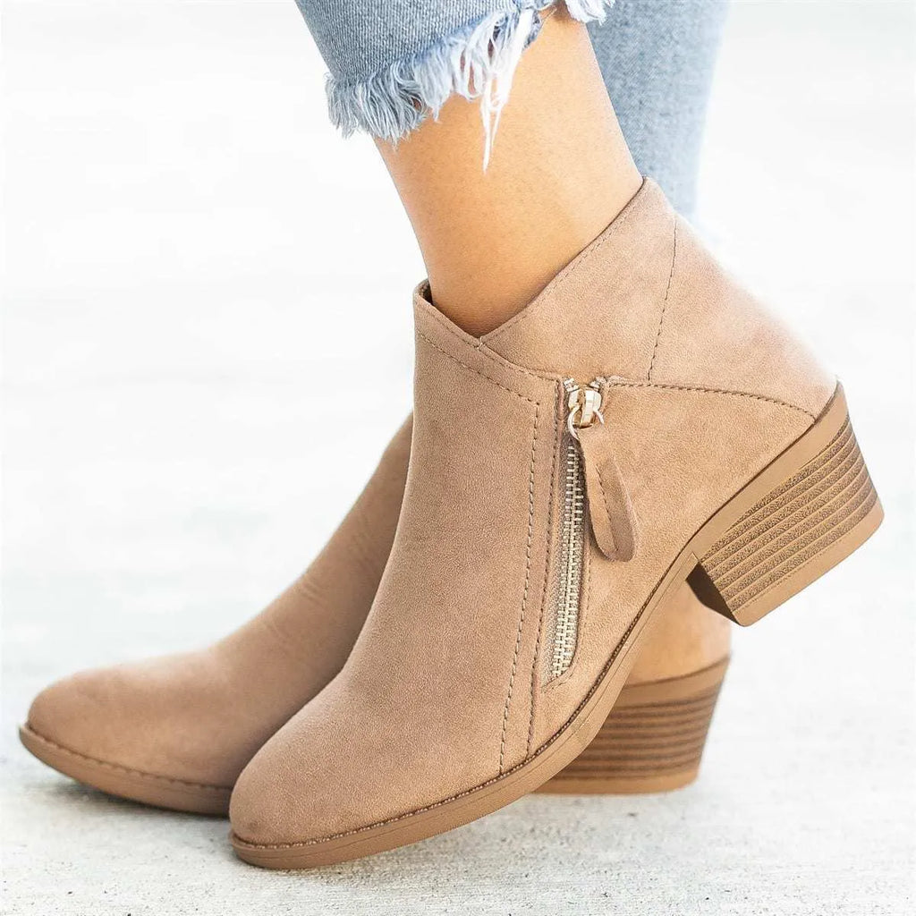 Blue Dr Martens women's suede ankle boots with a side zip and chunky heel on a white background.