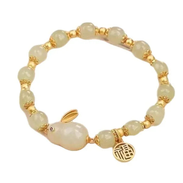 Green jade lucky bracelet with black hare charm, fu character, and lily flower on black adjustable cord.