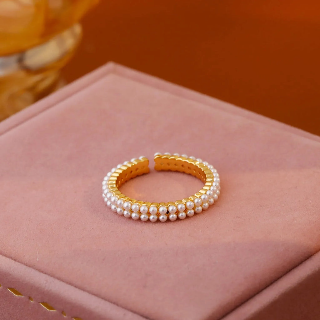 Gold geometric open mouth ring with round decorative elements on female hand
