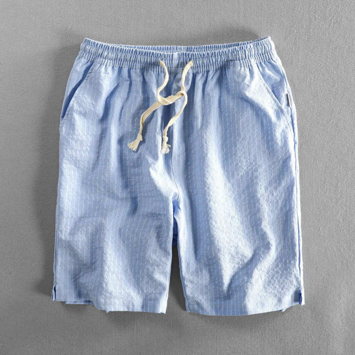 Men's striped cotton casual shorts in a loose straight fit on a mid-waist, shown in light blue colour.