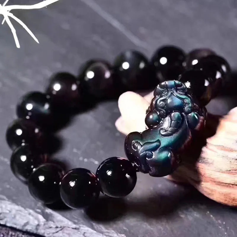 Natural ice colour Eye Obsidian crystal beaded bracelet on a wrist, showing round beads.