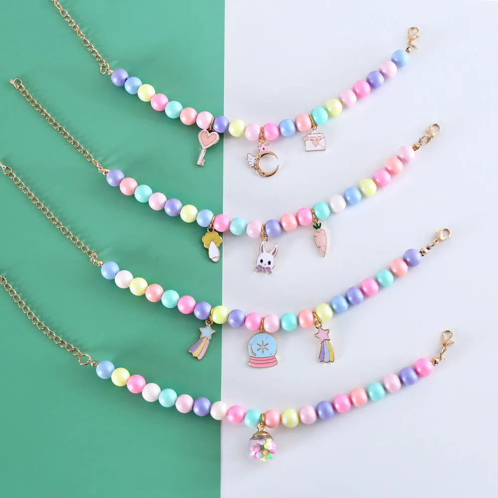 Colourful macaron charm pet collar and matching bracelet set in resin on a white background.