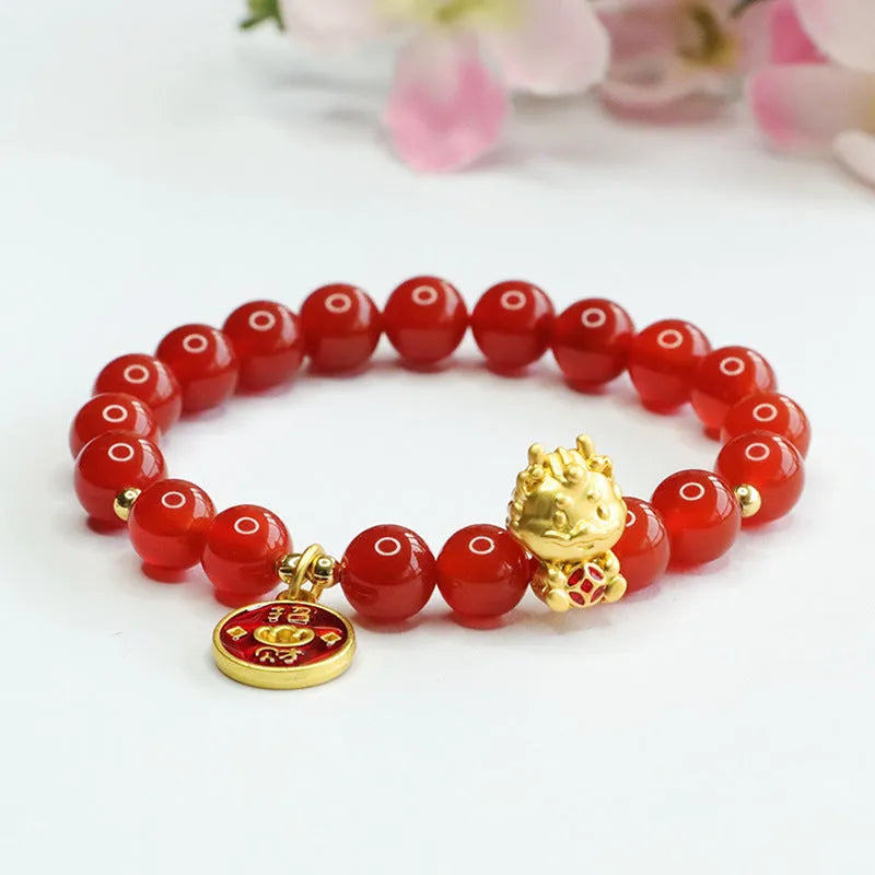 Close-up of a red agate beaded bracelet with a Chinese zodiac dragon charm on a wrist.