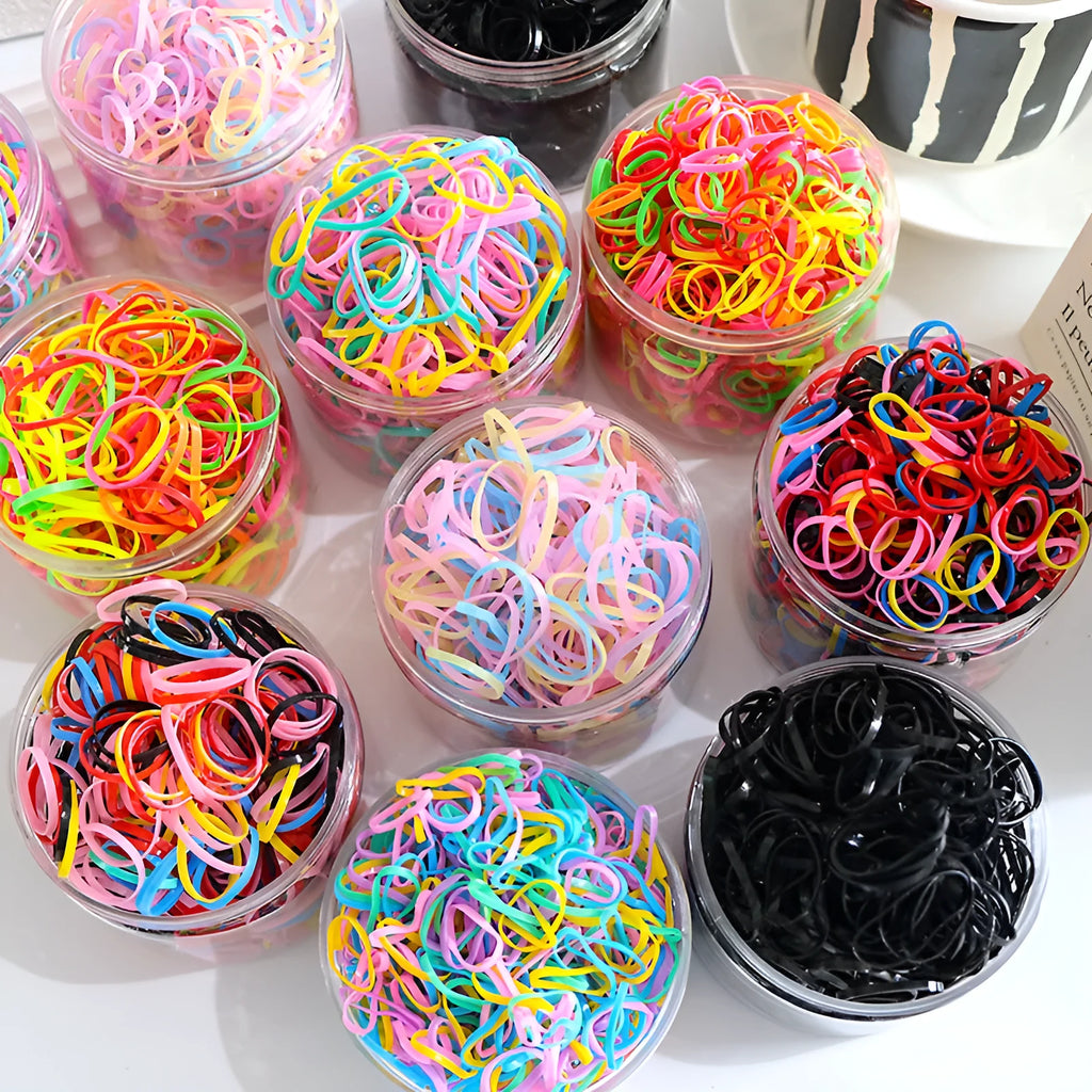 Multi-colour TPU baby hair ties for toddlers stored in a reusable clear container.