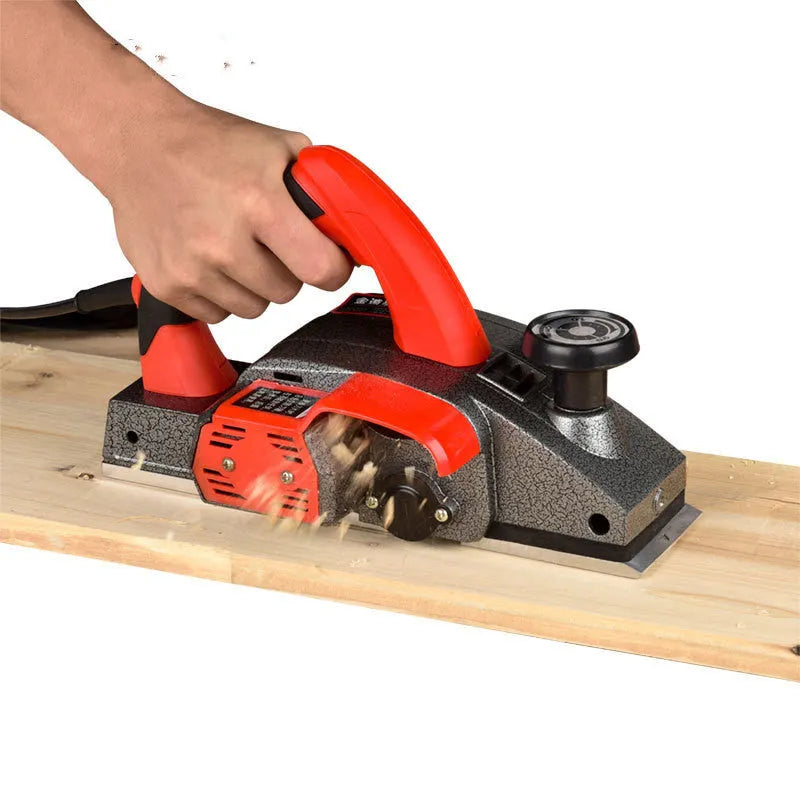 Red desktop electric wood planer with aluminium body showing 82mm cutting width