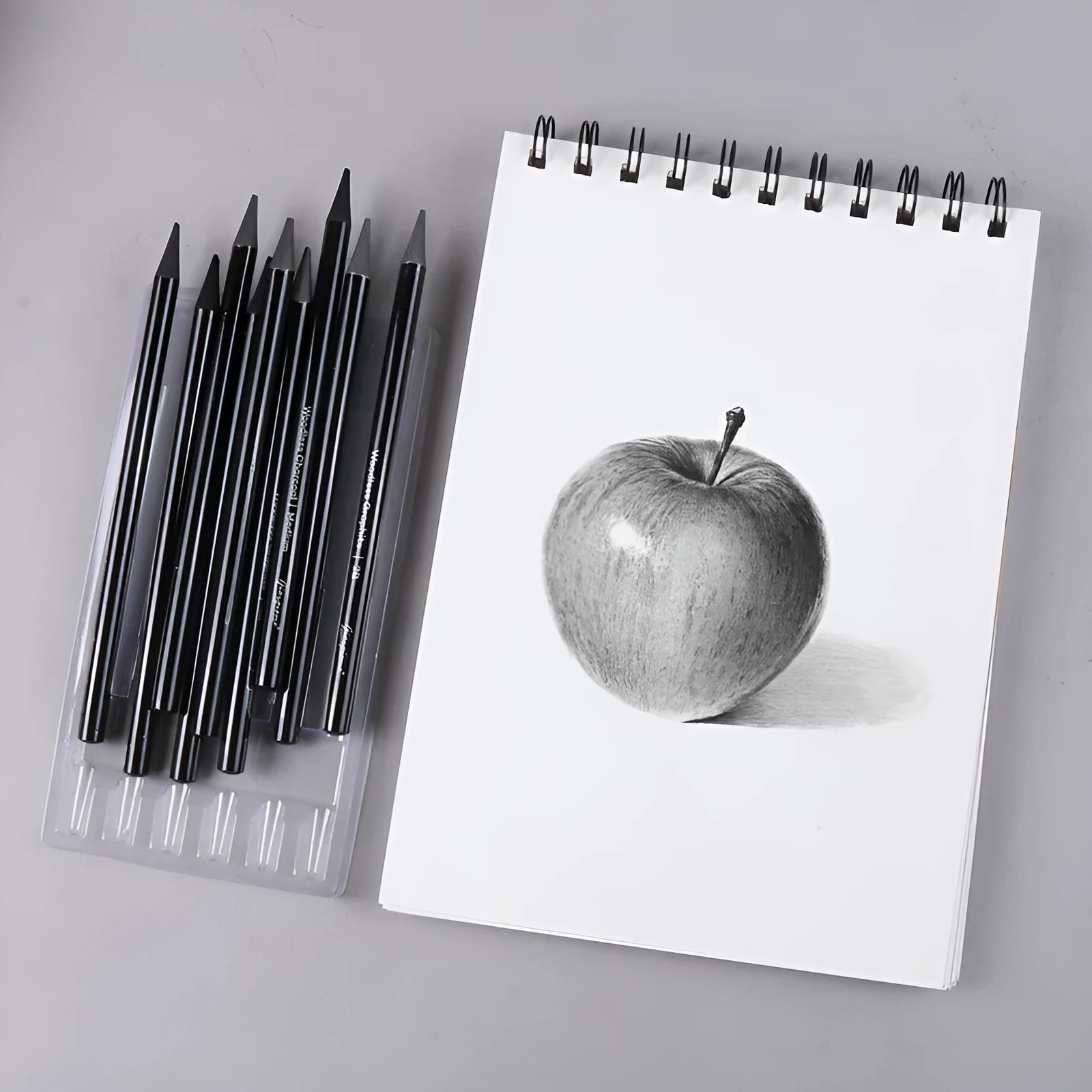 Set of six graphite and three carbonized drawing pencils with wooden casings on a suction card.