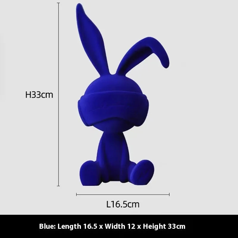 Suede blindfold rabbit resin table ornament in chosen colour on a wooden surface.