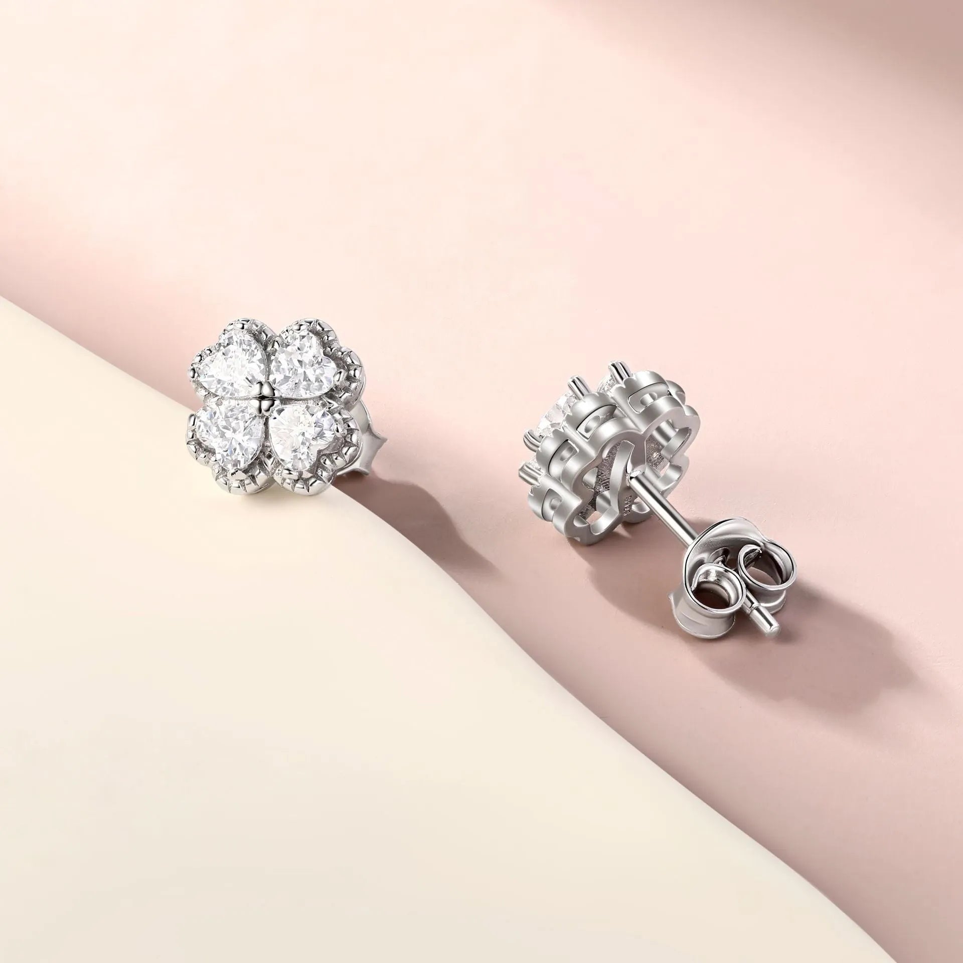 Pair of heart-shaped sterling silver stud earrings with a four-leaf clover design and a central zircon stone.