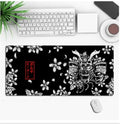 Custom anime graphic gaming mouse pad with non-slip rubber base on a desk.