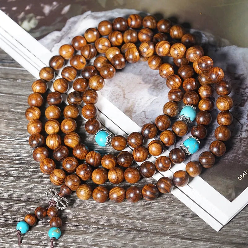 Handmade geometric bracelet with 108 smooth Lvzhu stone beads.